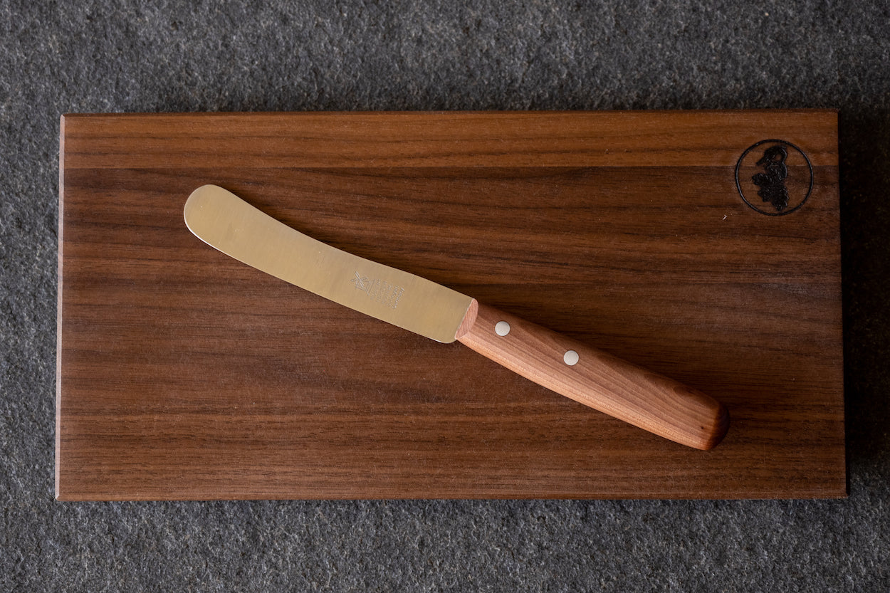 Windmühlenmesser Buckels Tischmesser mit Griff aus Birnenholz, auf einem Brotzeitbrett aus Nussbaum. Klinge 11,5 cm. 
