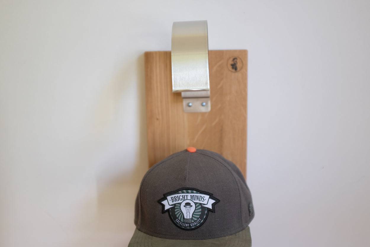 Detailaufnahme eines Edelstahl Caphalter auf einem Eichenholz Brett montiert.