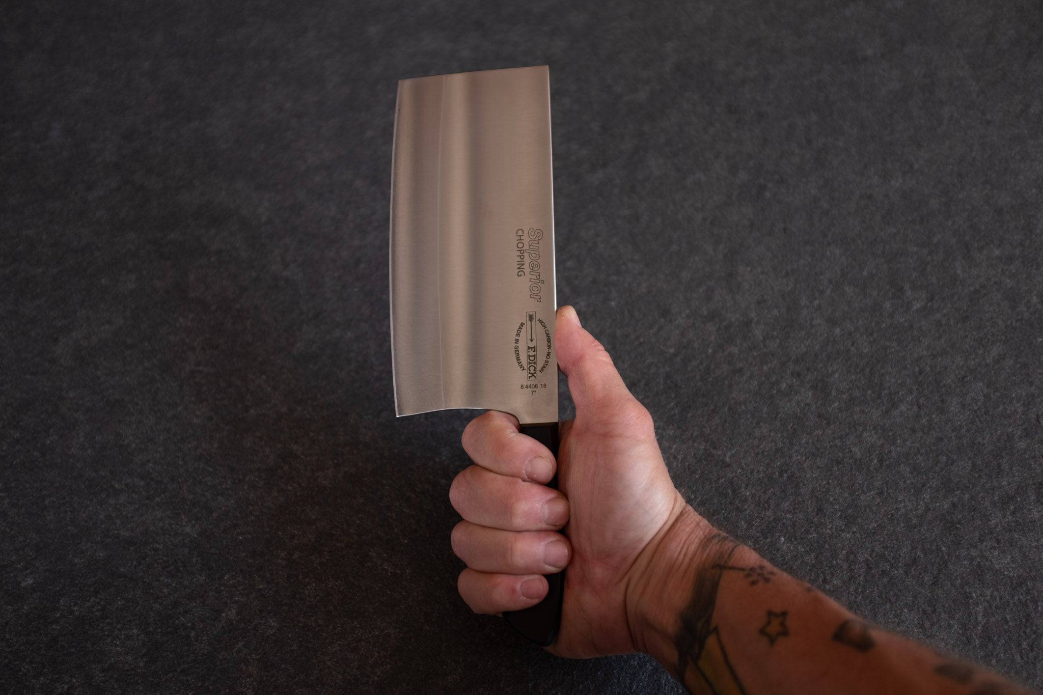 In der Hand ein chinesisches Kochmesser von Dick.