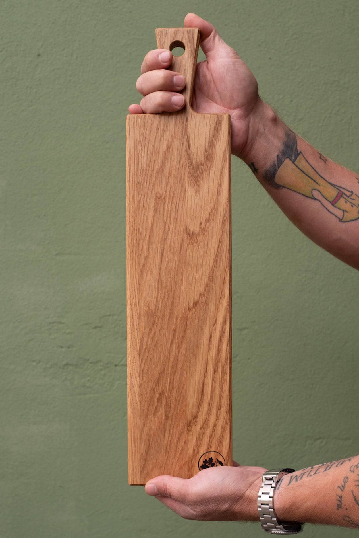 Servierbett aus Eiche in Händen gehalten