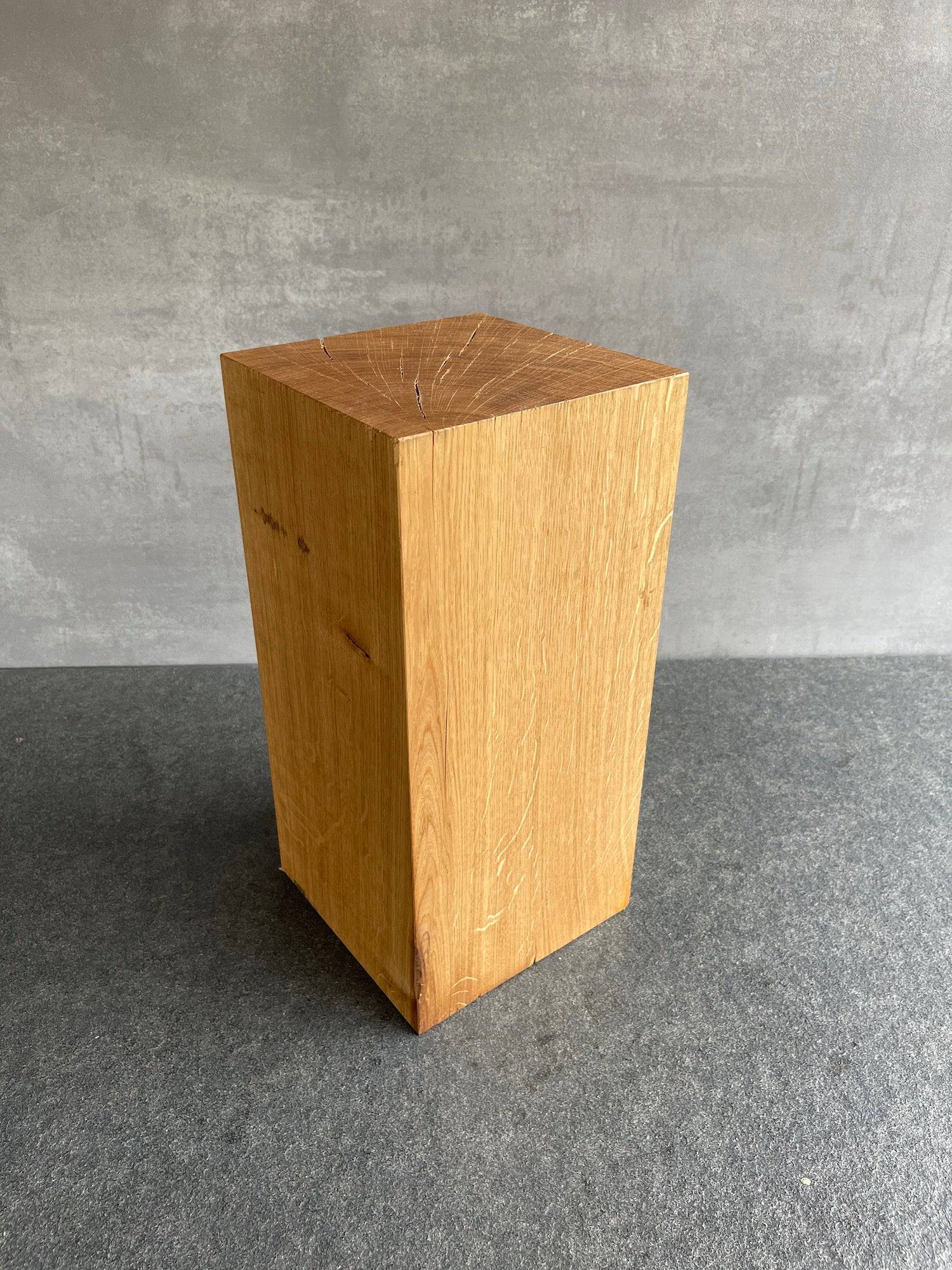 Eichenblock 40 cm hoch und 20 mal 20 Zentimeter. Stehend auf einer grauen Arbeitsplatte