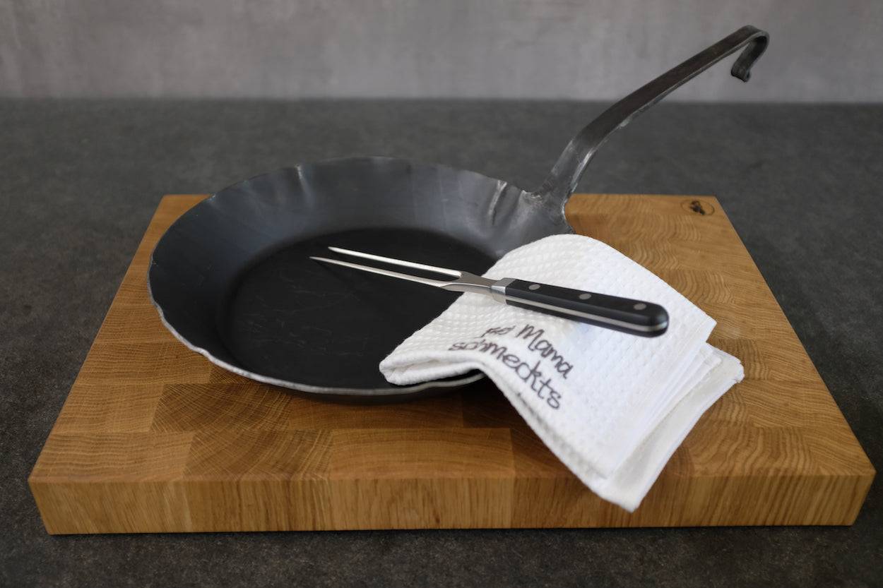 In Deutschland hergestellte Eisenpfanne auf einem Eiche Hirnholz Schneidebrett.