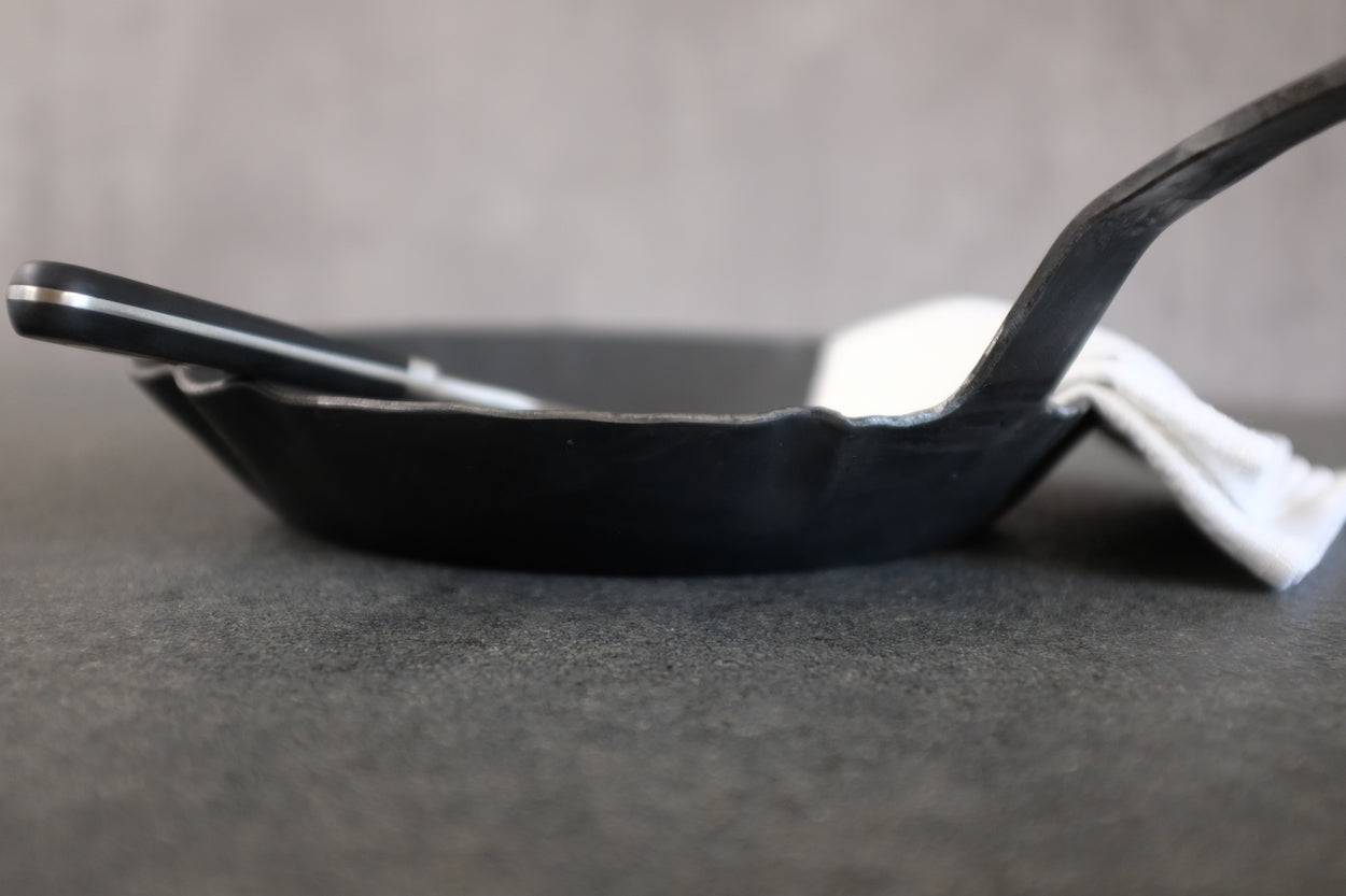 Eisenpfanne auf einer Steinplatte mit Dekor.