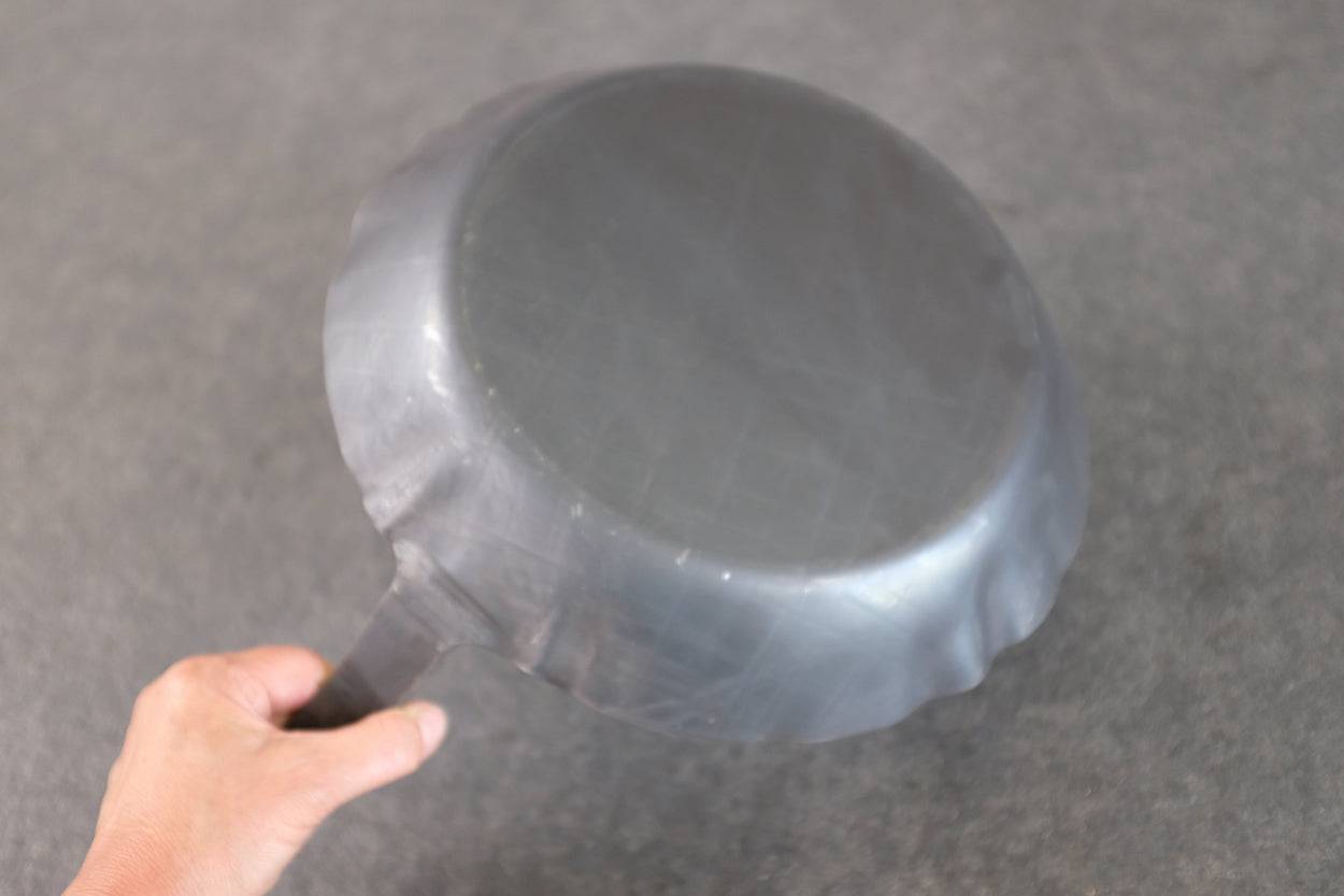 Rückseite einer Eisenpfanne.