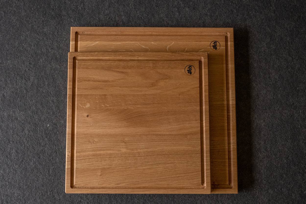 Zwei quadratische Schneidebretter aus Eiche mit Saftrille. Das kleine ist das "Faulbach".