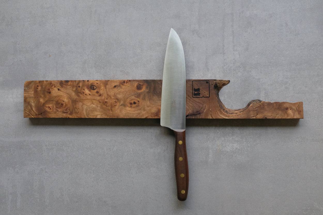 Maserulme massiv. Magnetmesserhalter für 5 Messer. An einer Betonwand mit einem Windmühlenmesser Kochmesser K5.