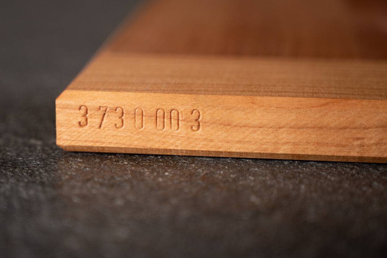 Eingeschlagene Seriennummer bei einem Kirschebackbrett ohne Anschläge