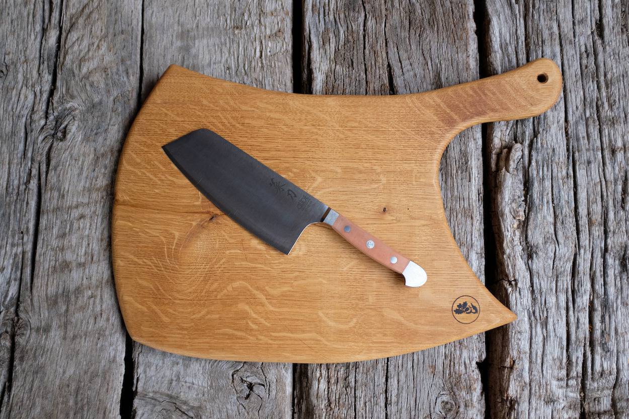 Güde Kochmesser Hackmesser auf einem Schneidebrett aus einem Stück Eiche Vollholz auf einem Eichenbalken.