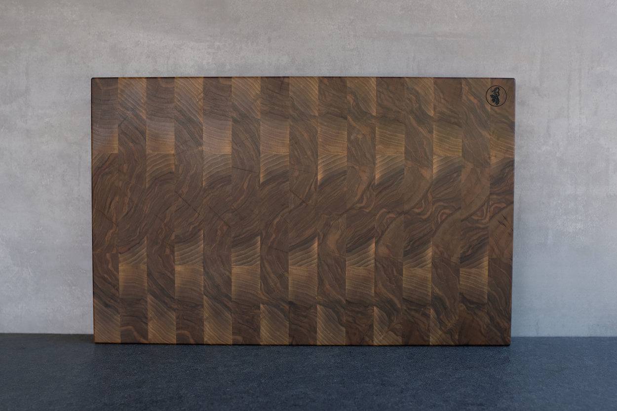 Vorderseite Nussbaum Hirnholz Einzelstück in 60x40 cm. Ann einer Betonwand angelehnt.