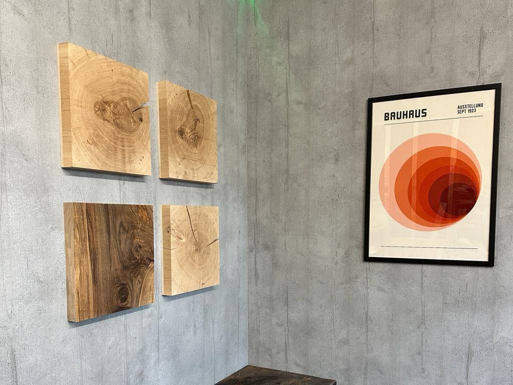 Dekoration von Kunst aus Holz. Wandbild aus Eiche im 4er Set an einer Wand. Rechts davon ein Bauhaus Bild im schwarzen Rahmen.