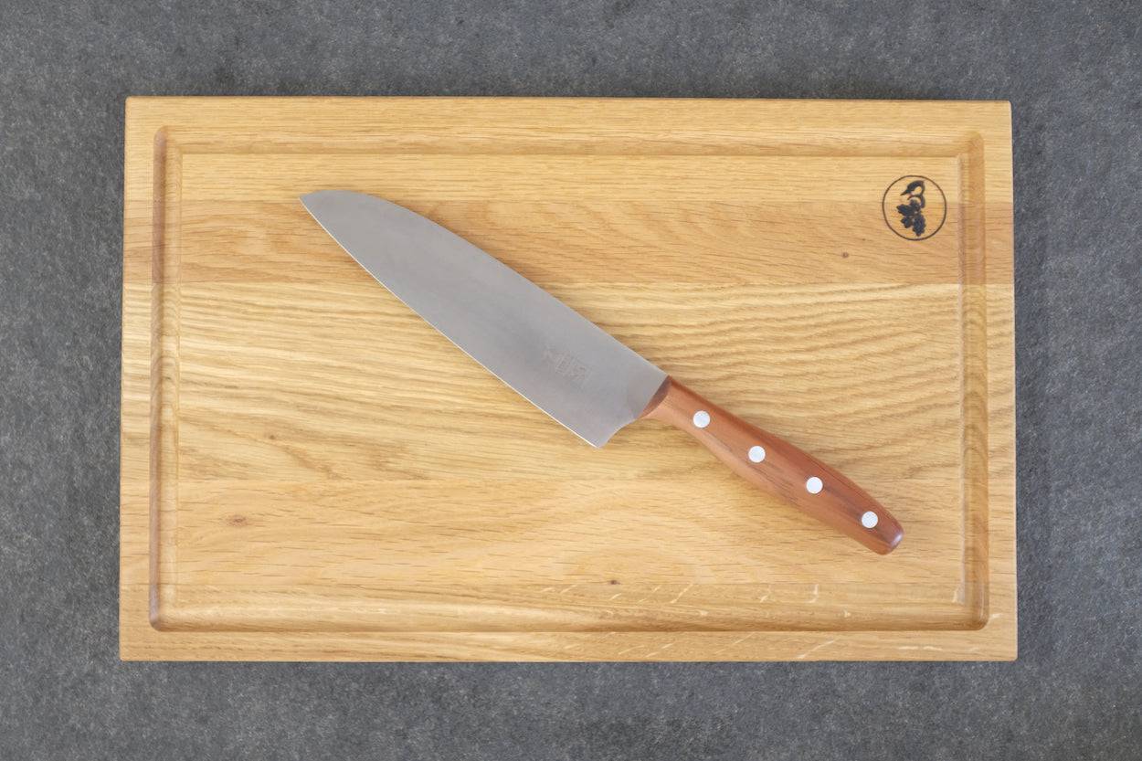 Windmühlenmesser K5 Kochemesser mit Pflaume-Griff auf einem Eiche Saftrillenbrett von Spessartbrett.