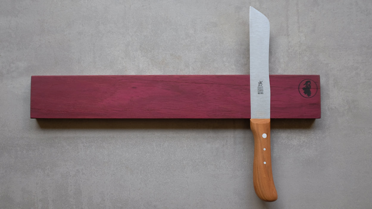 Amaranth, Edelholz, magnetischer Messerhalter für 6 Messer an einer Betonwand montiert. Mit einem Windmühlenmesser Brotmesser Hamburger.
