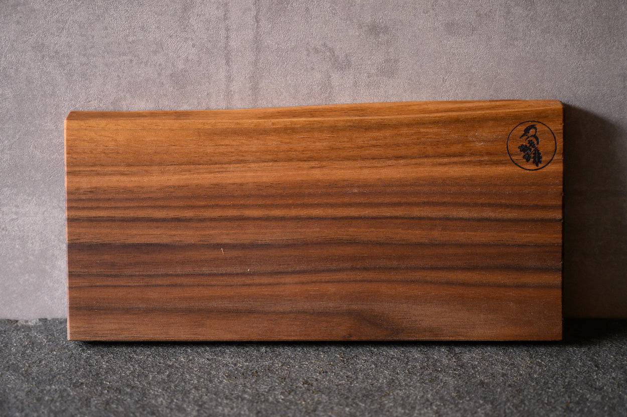 massives Schneidebrett aus einem Stück Nussbaum mit einer Baumkante