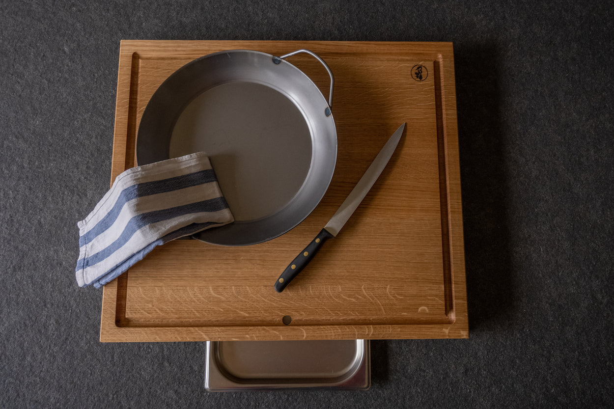 Eicheschneidebrett mit einer Saftrille und eingebauter Auffangschale aus Edelstahl, versehen mit Messer, Pfanne und Küchentuch 