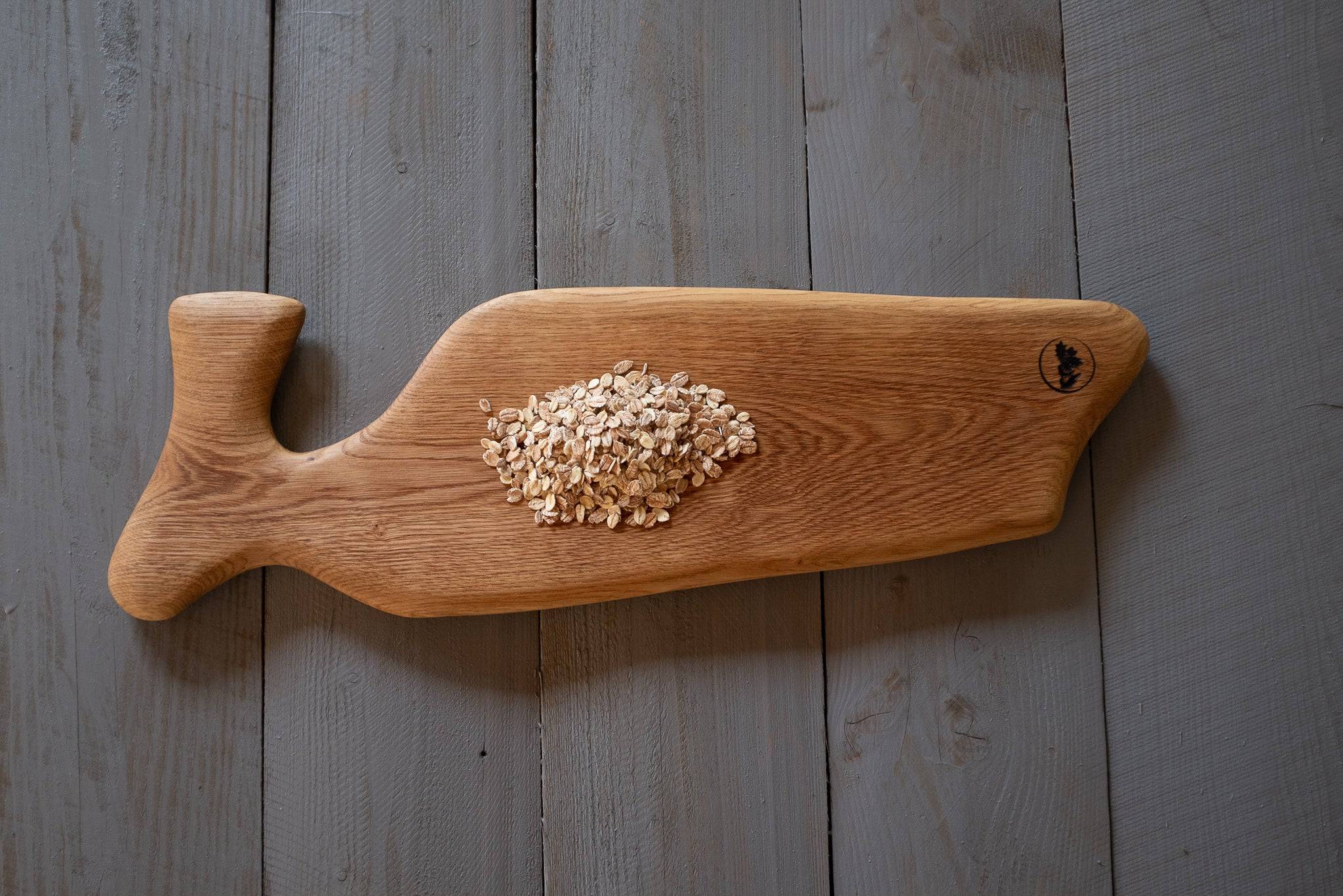 Vorlegebrett mit Haferflocken auf Holz nach rechts zeigend