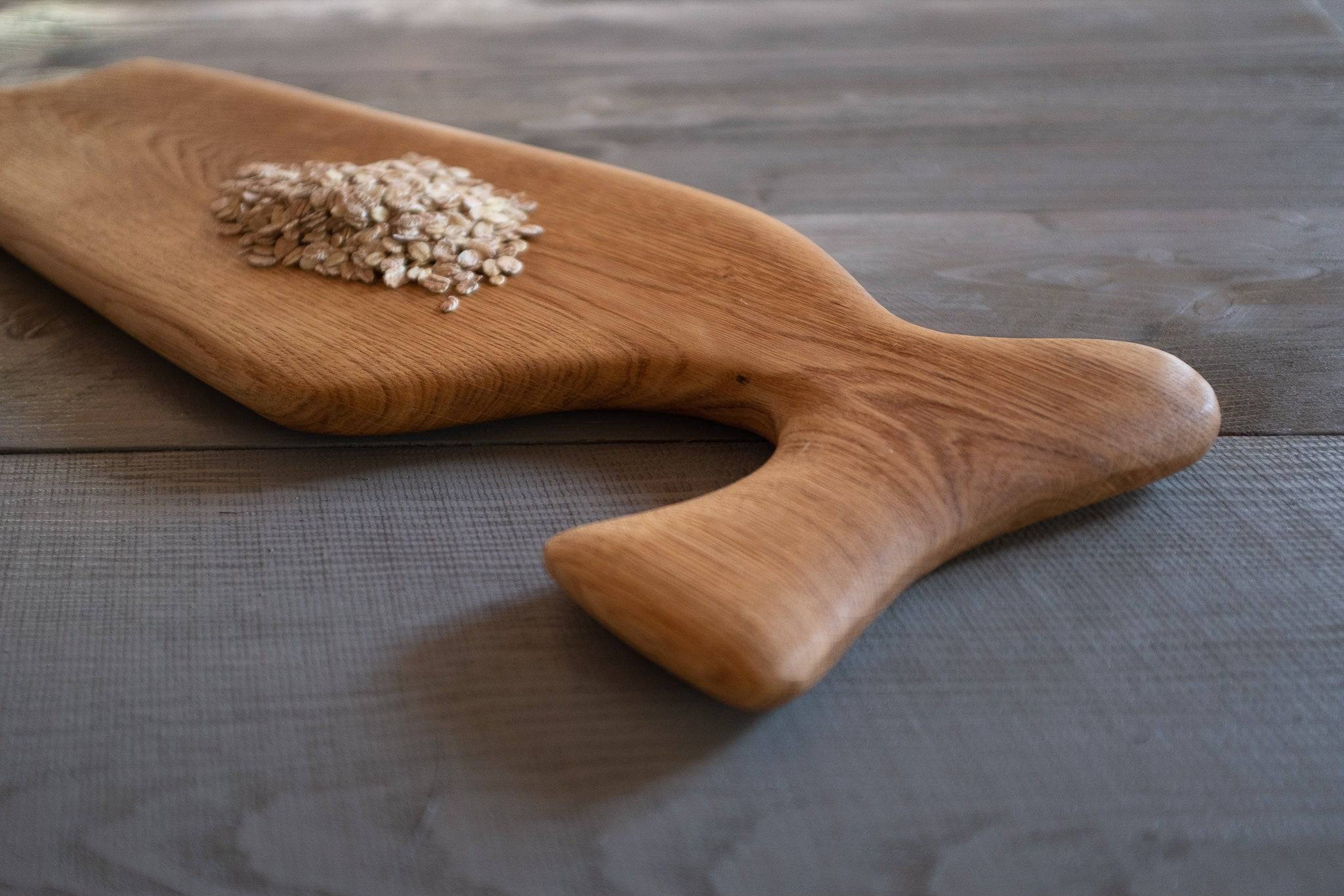 Nahaufnahme vom Vorlegebrett mit Haferflocken auf Holz
