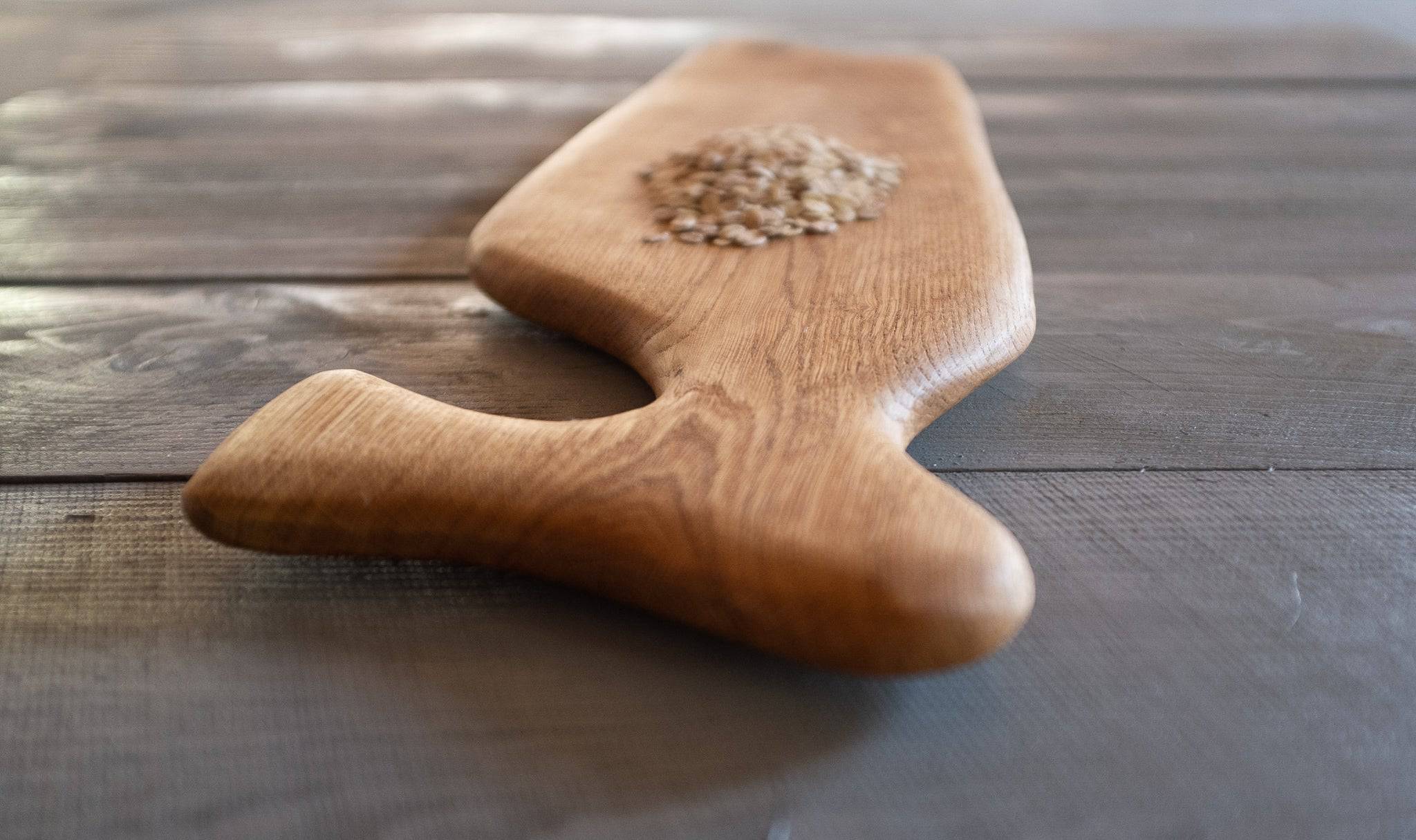 Nahaufnahme vom Vorlegebrett mit Haferflocken auf Holz