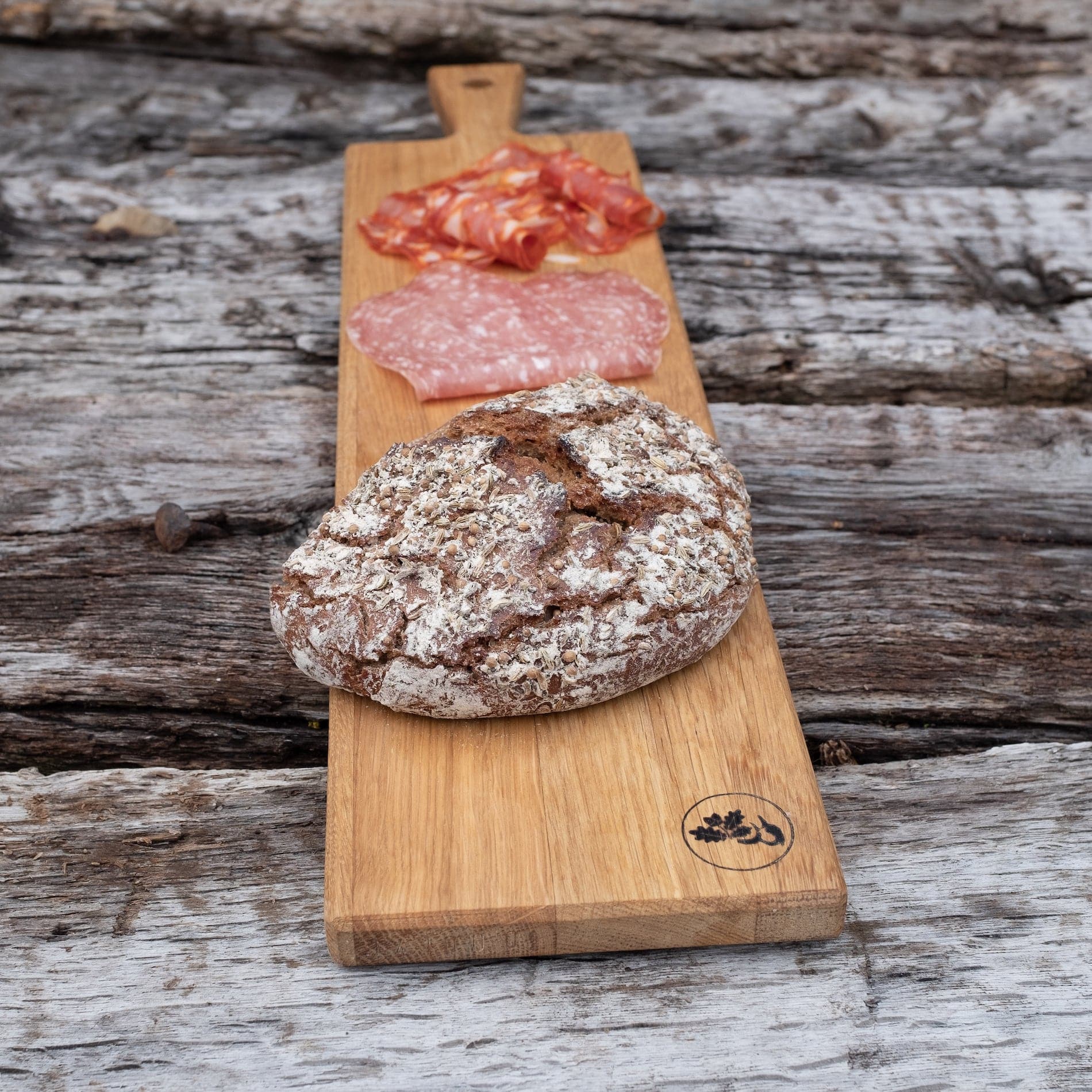 Eiche Servierbrett mit einem Laib Brot und Salami.