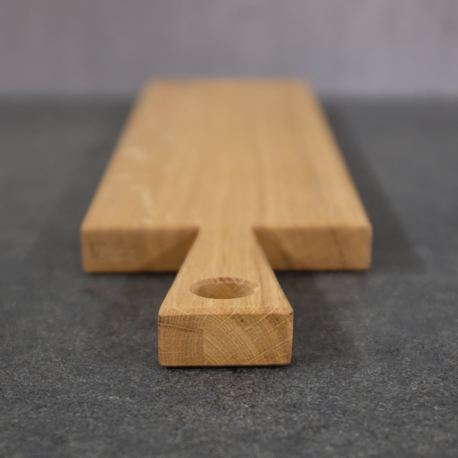 Detailaufnahme eines Eiche Servierbrett. Man sieht den Griff und ein Griffloch.