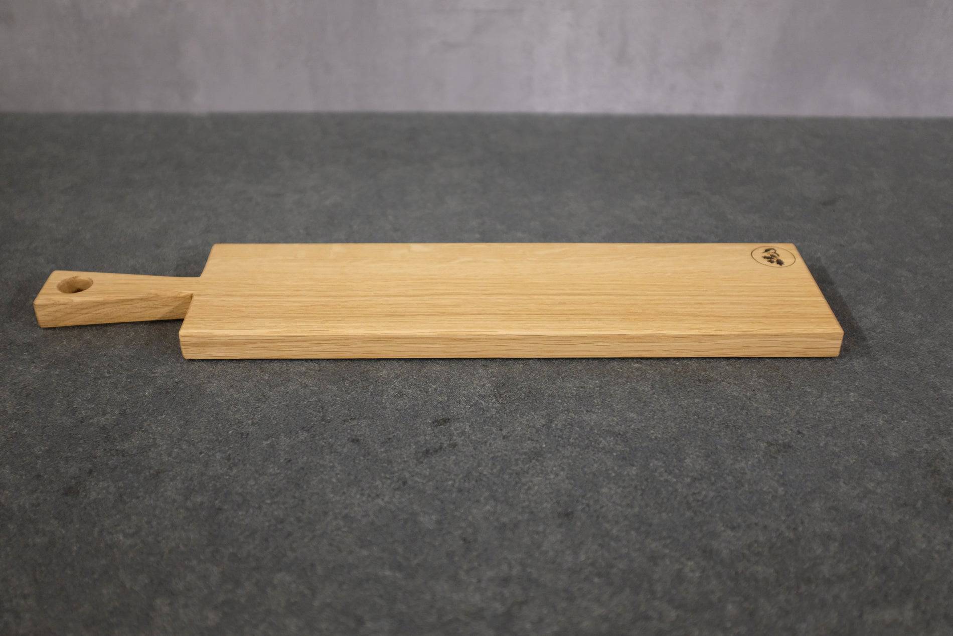 Spessartbrett Servierbrett aus Eiche "Sandkaute". Das Servierbrett liegt auf einer dunklen Steinplatte