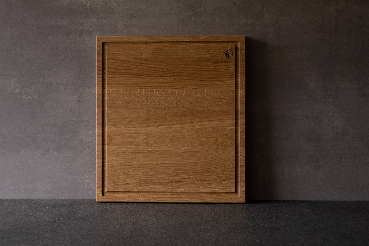 Tiefer Schneideblock aus Eiche mit Saftrille an einer Betonwand.