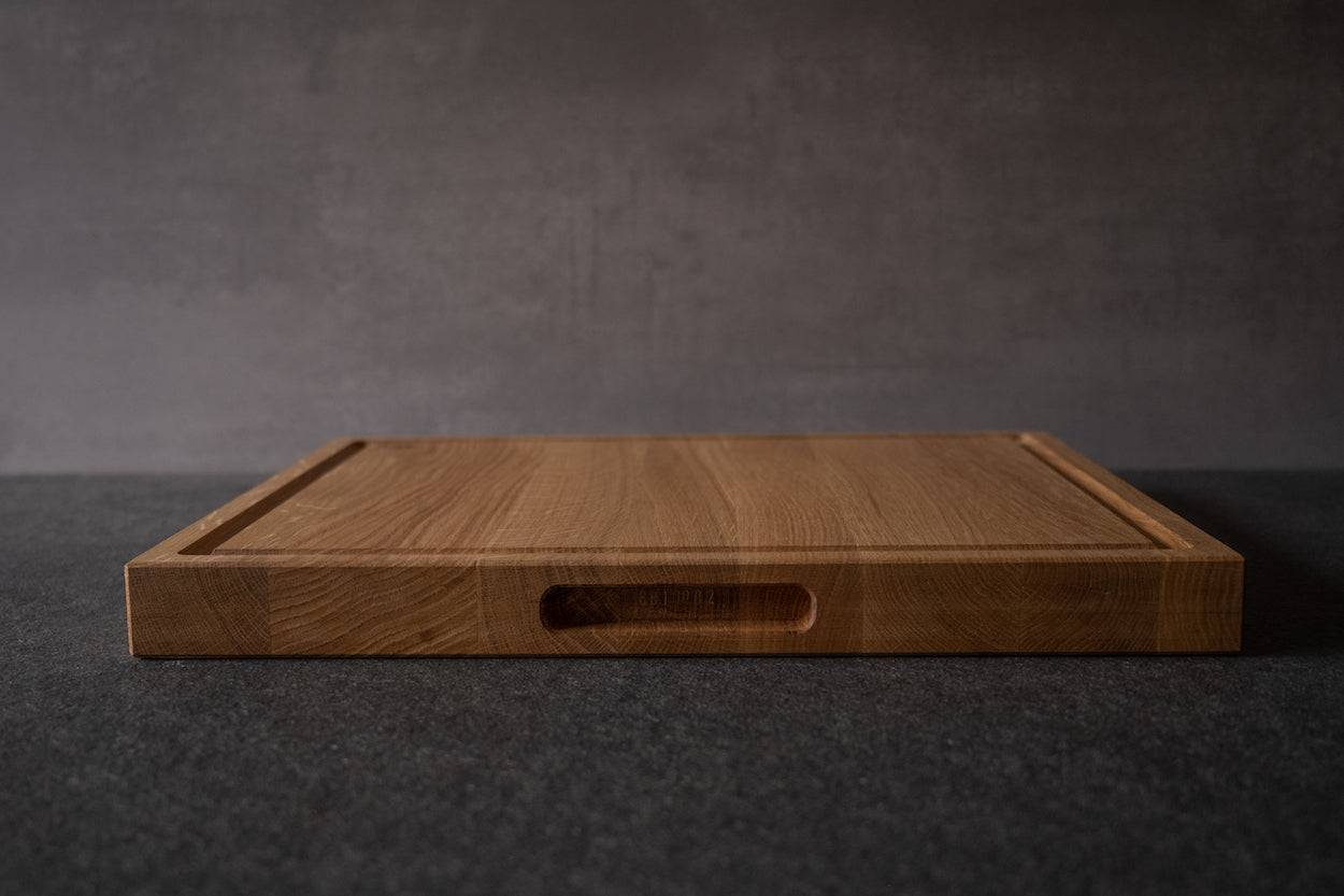 Schneideblock liegend auf einer Steinplatte. Griffmulde und Saftrille sichtbar.