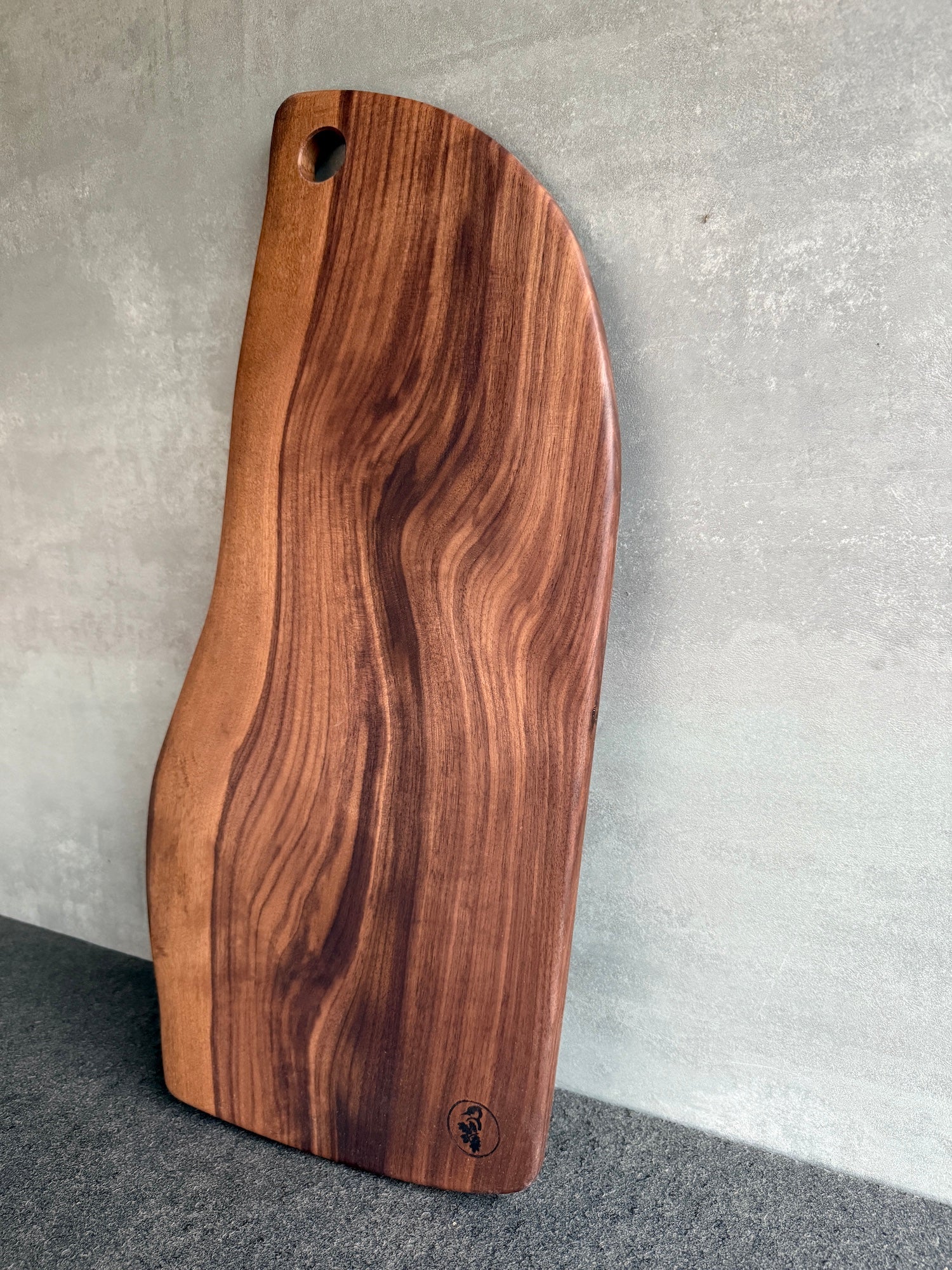 Nussbaum Schneidebrett aus Vollholz, an einer Betonwand angelehnt
