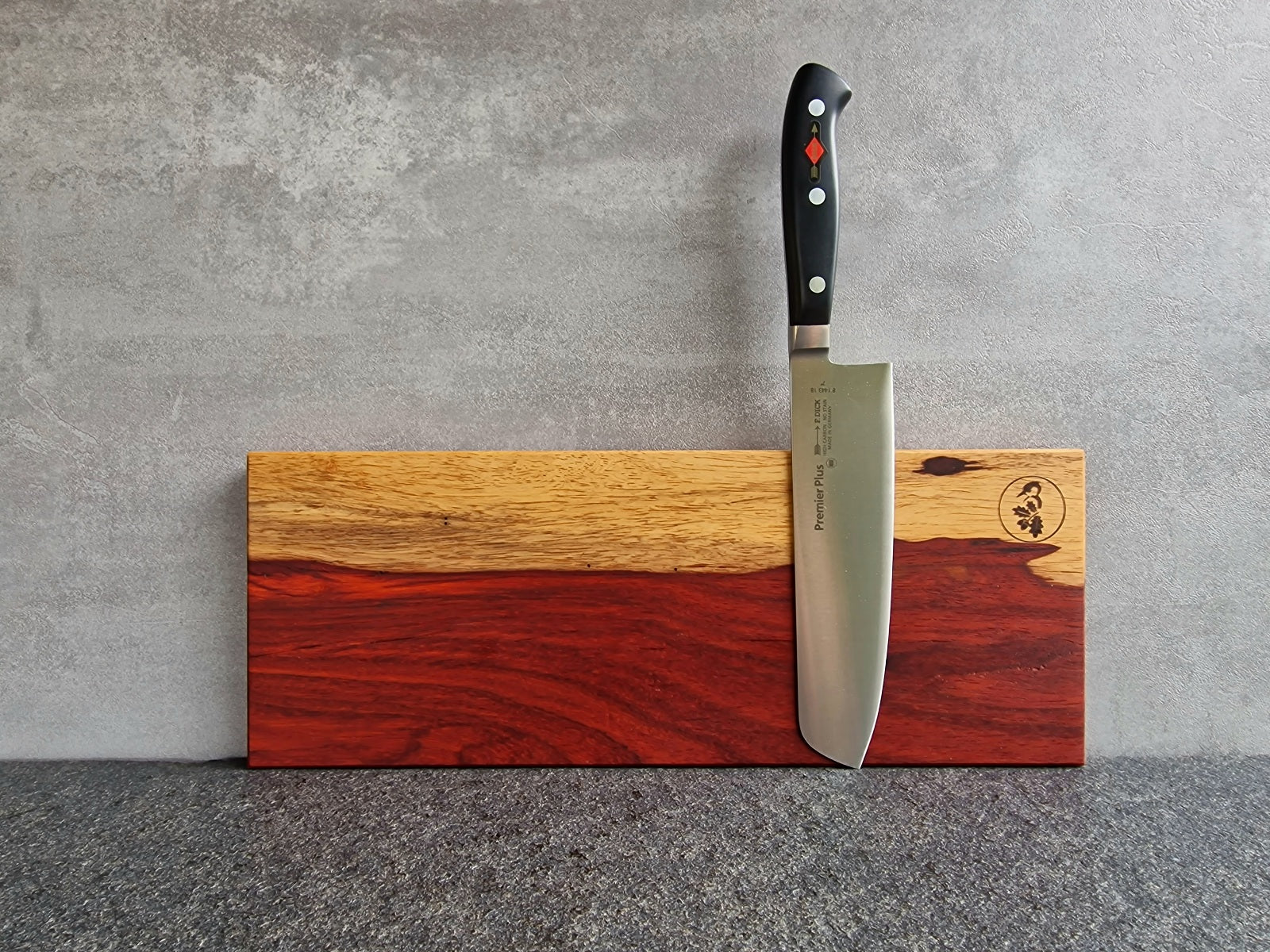 UnikatMagnetische Messerleiste aus rotem Padouk mit hellem Splint durchzogen. Montiert an einer Betonwand mit einem Dick Usuba Gemüsemesser.