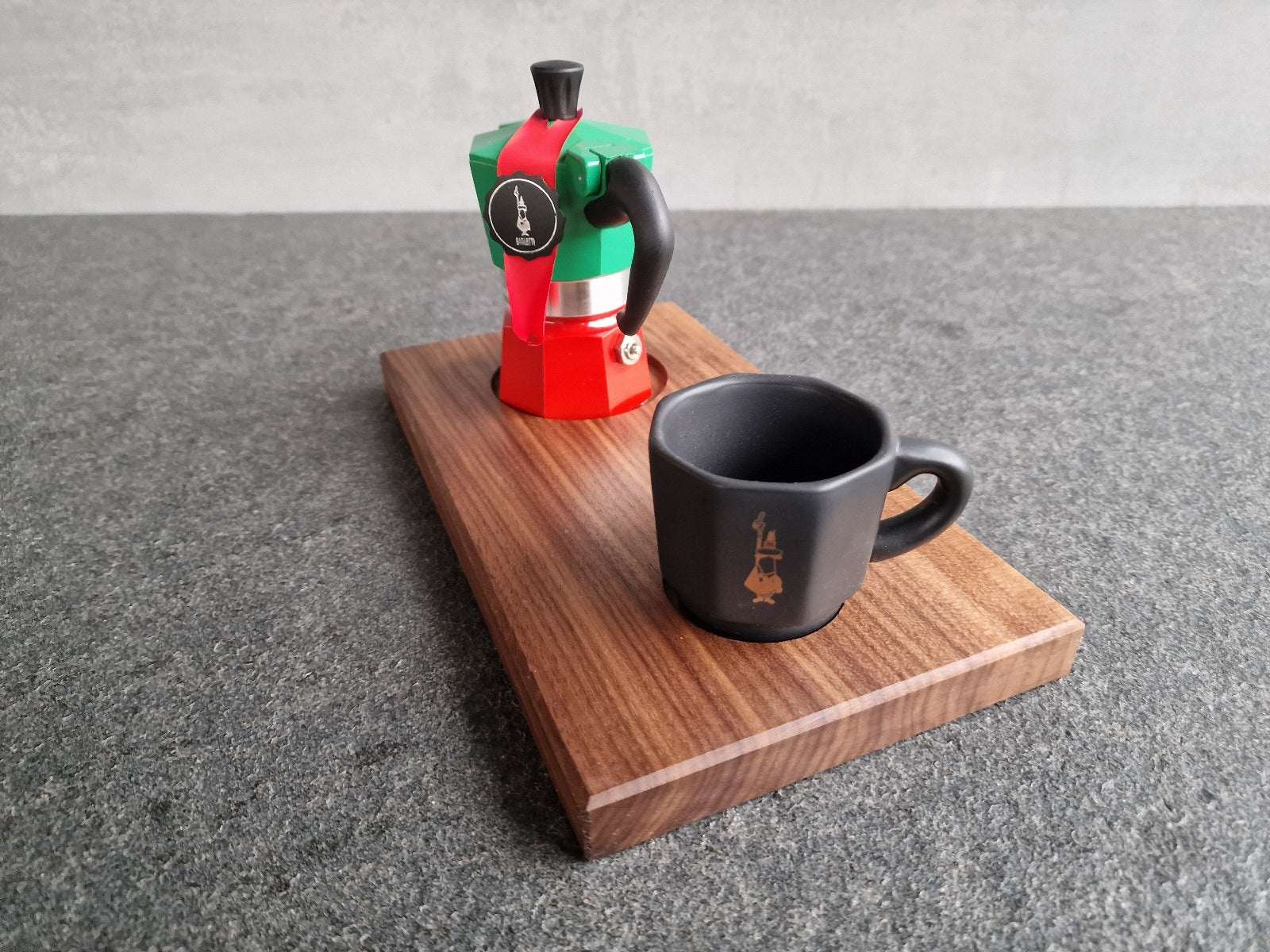Bialetti Espressokocher und eine schwarz Bialetti Espressotasse auf einem Nussbaum-Holztablett