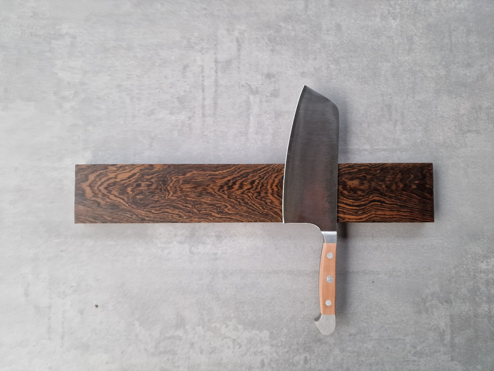 Magnetischer Wandhalter für Messer aus Bocote. Montiert an einer Wand mit einem Güde Koch Messer