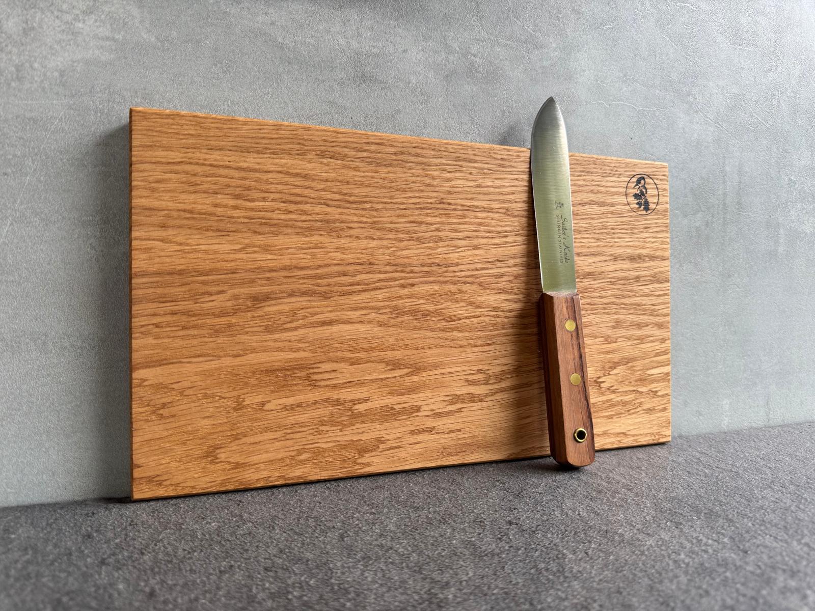 Detailaufnahme der Brettkante mit Messer, Struktur und Ölglanz sichtbar.