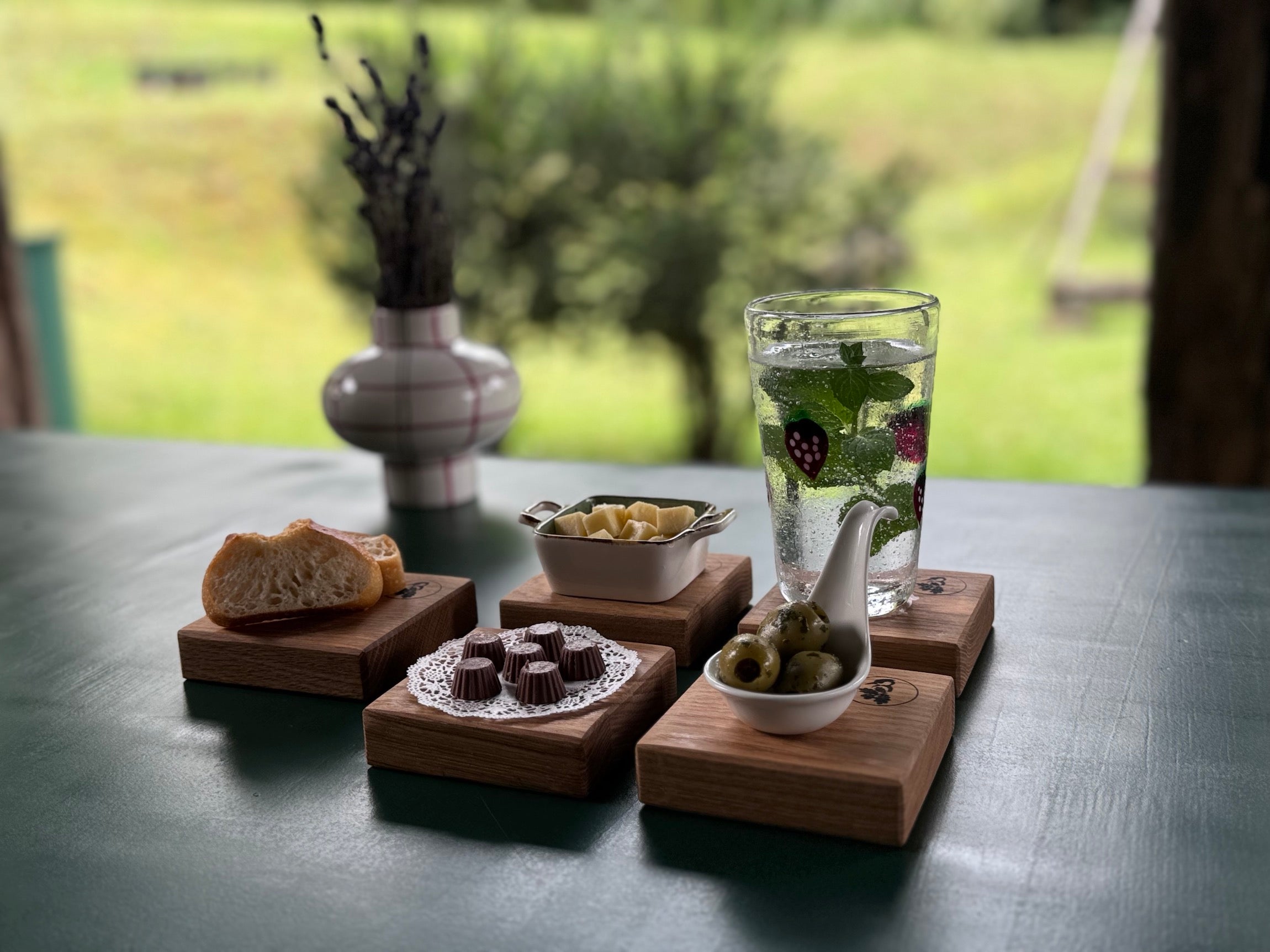 Brot, Käse, Oliven, Pralinen, La Fresa Wasserglas auf Eiche Untersetzern.