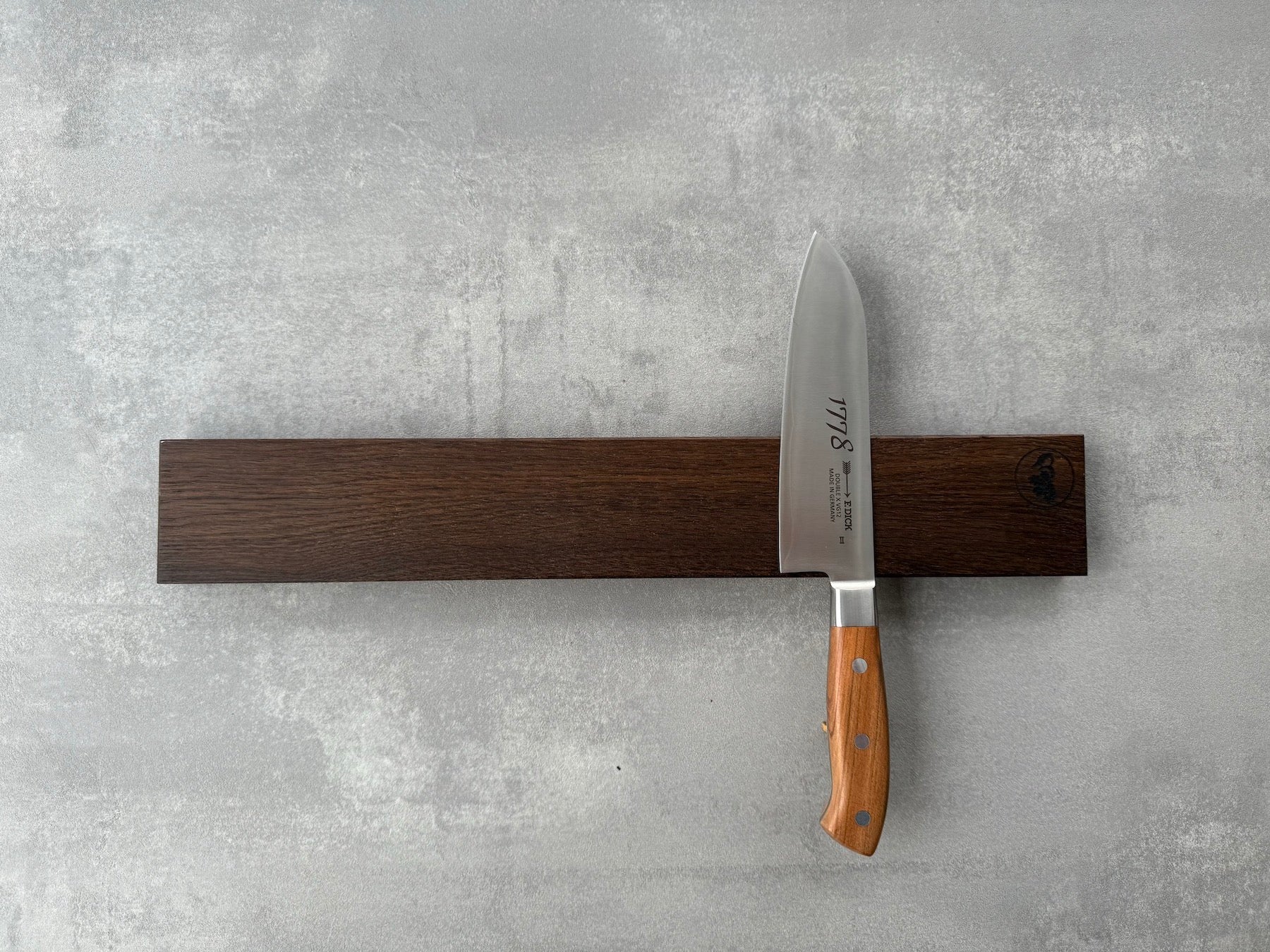 Wandmesserhalter, magnetisch, für 8 Messer, an einer Betonwand. Mit einem Dick Kochmesser dekoriert.