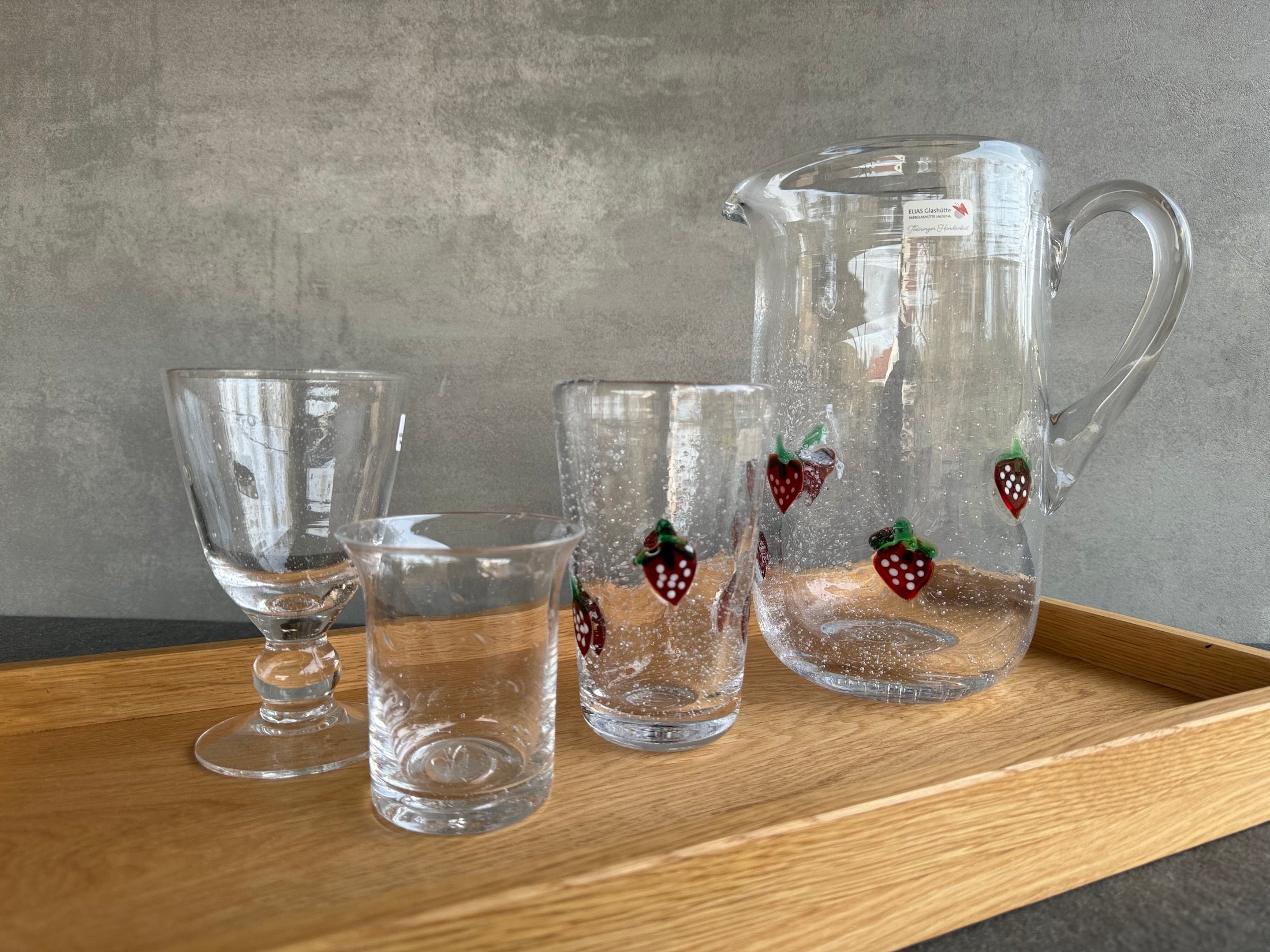 La Fresa Sommerglasserie: Wasserkrug und Wassergläser mit aufgelegten Erdbeeren.
