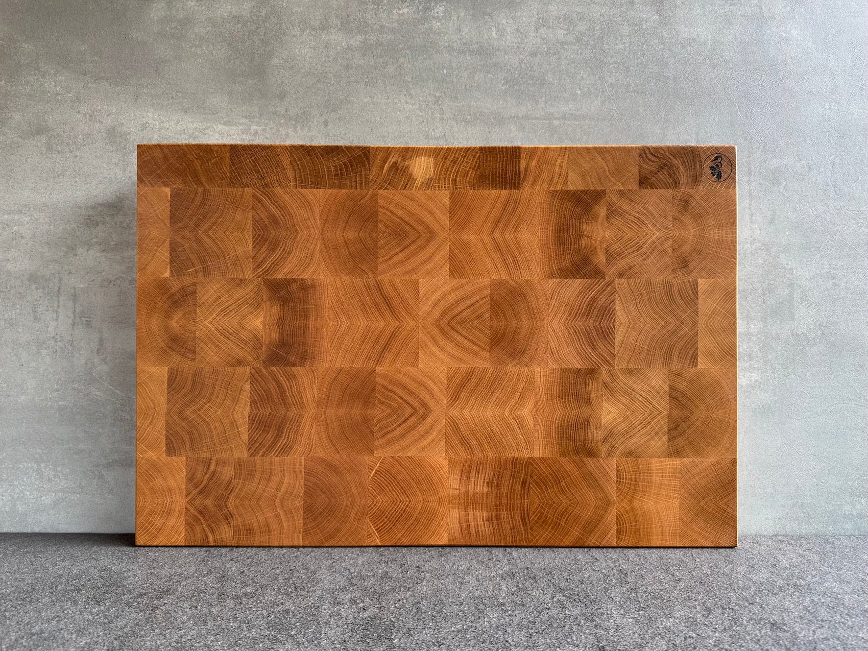 Eiche Hirnholz Schneideblock mit toller Maserung, 60 cm breit, an einer Betonwand.