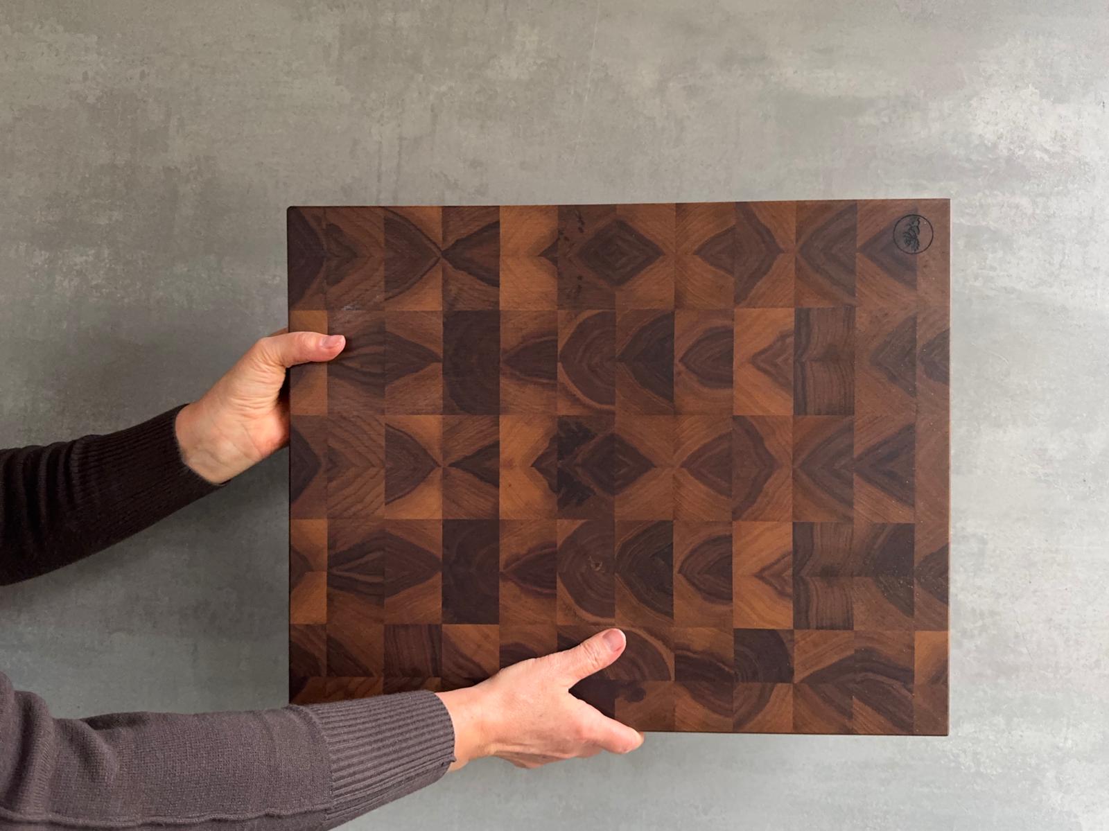 Hände halten einen Nussbaum Schneideblock hoch