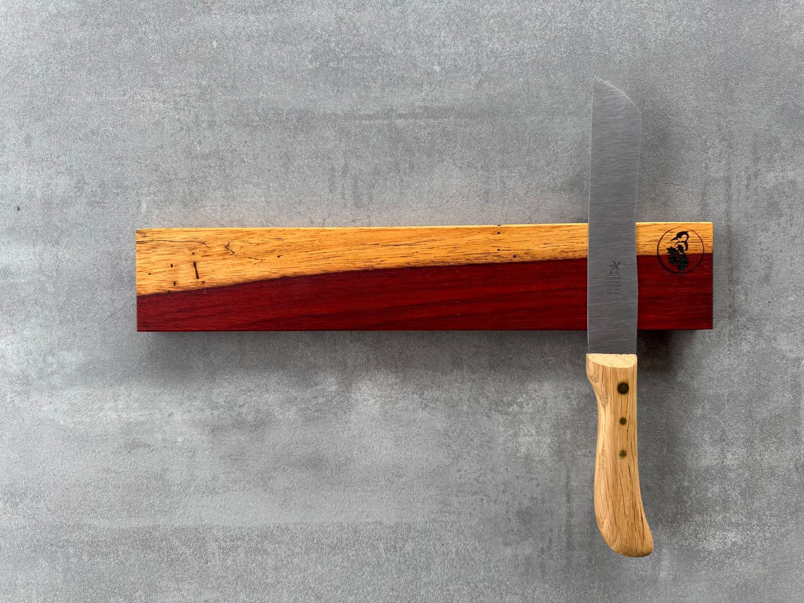 Messerleiste aus leuchtend rotem Padouk  mit Splint für 6 Messer. Dekoriert mit einem Brotmesser Hamburger.