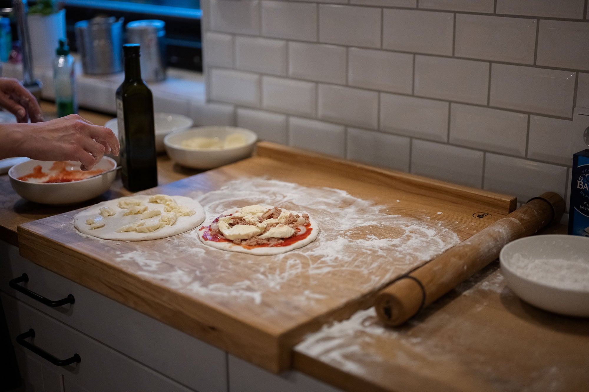 Backbrett aus Eichenholz mit zwei Anschlägen in der Küche im Einsatz bei der Pizzazubereitung