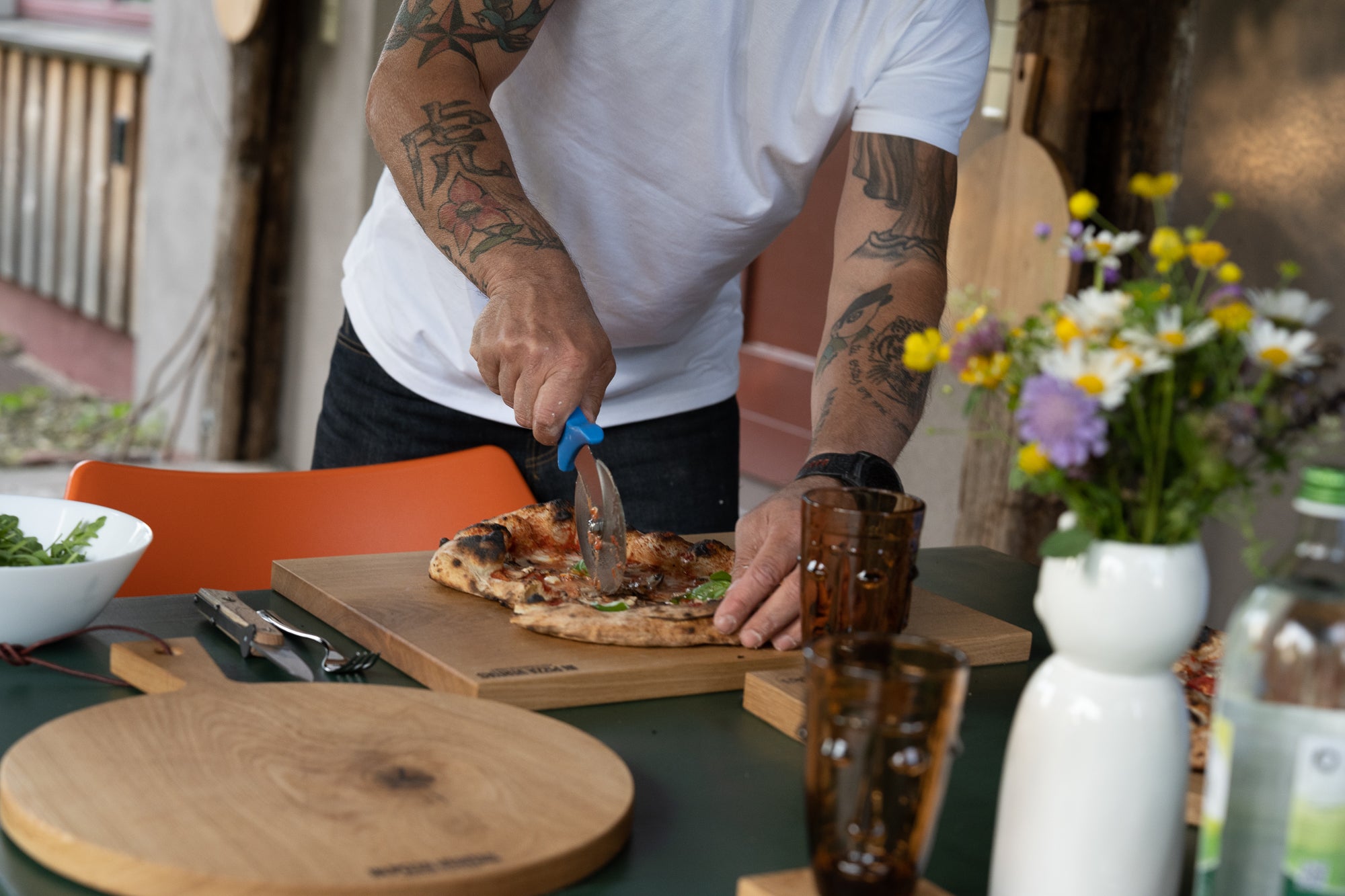 Pizza wird mit einem Pizzaroller von Gi.Metall geschnitten.