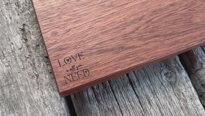 Kurzfilm über ein rötliches Edelholzbrett aus einem Stück mit gerader Kante. Personalisiert mit „Love“ für Mutter- oder Vatertag.