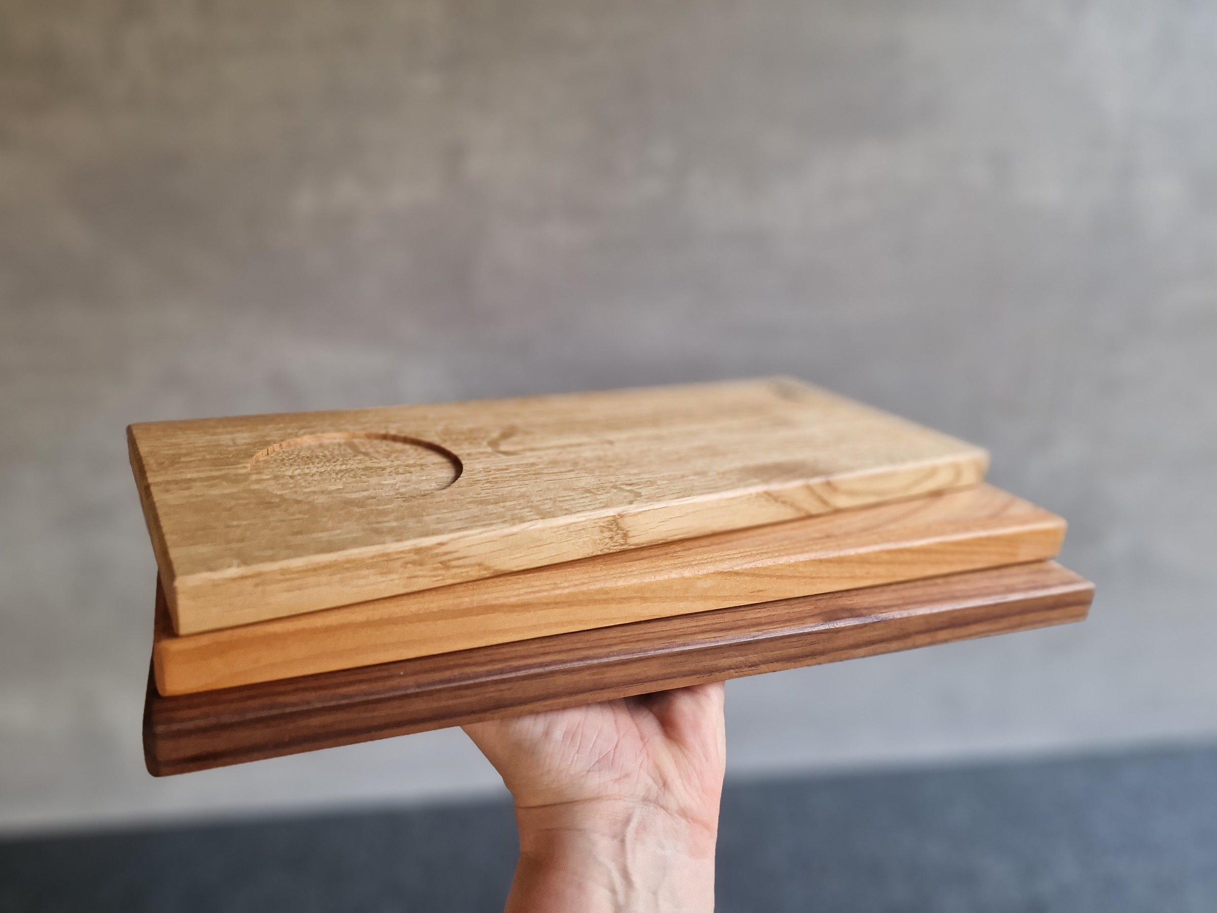 Rechteckiges Tassen Holz Tablett aus Eiche, Kirschbaum und Nussbaum. Auf einer Hand präsentiert. Mit einer Mulde für eine Tasse.