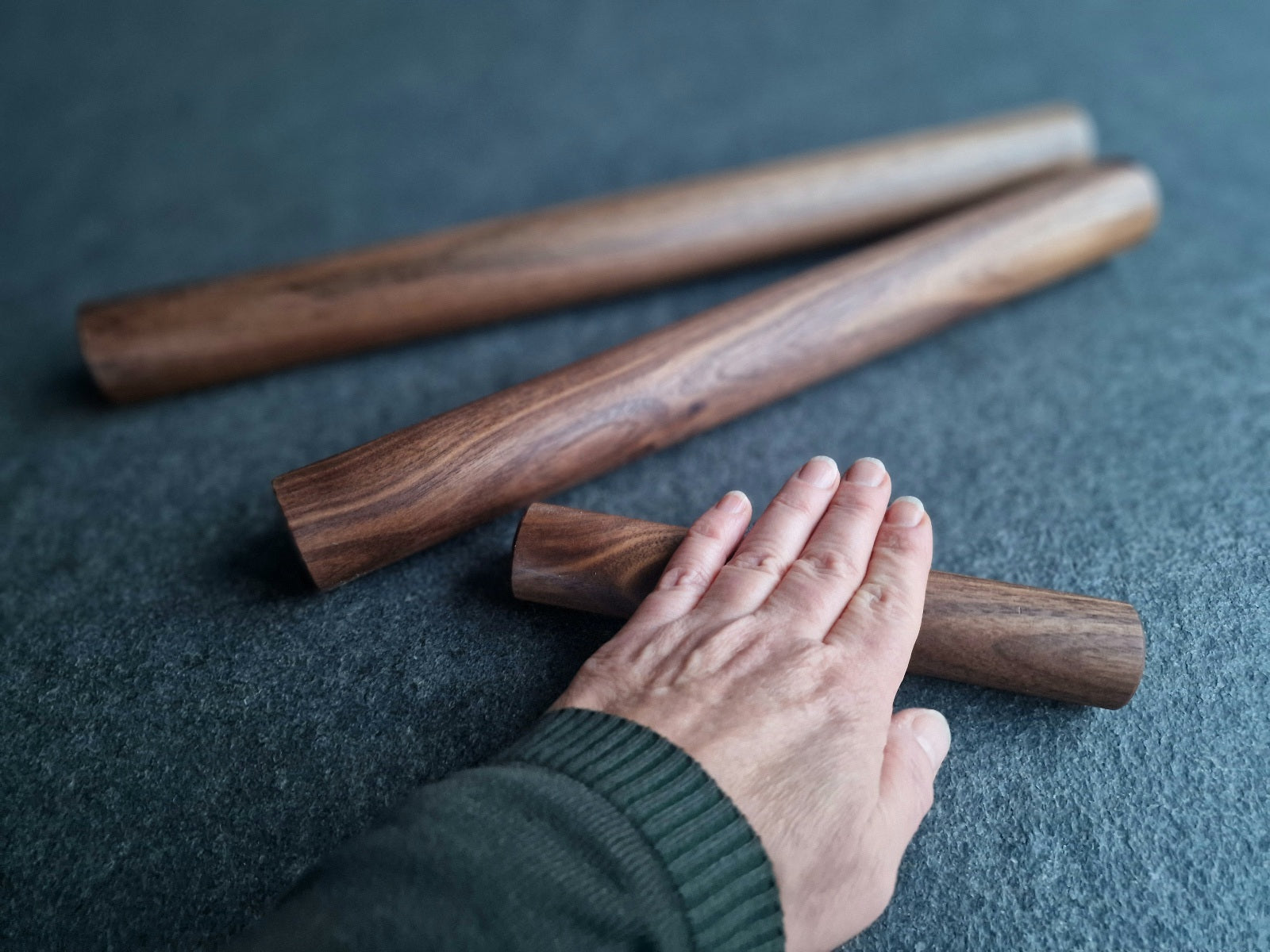 20 cm, 40 cm und 50 cm lange Teigrolle aus Nussbaum. Vergleich Hand und 20 cm lange Teigrolle.