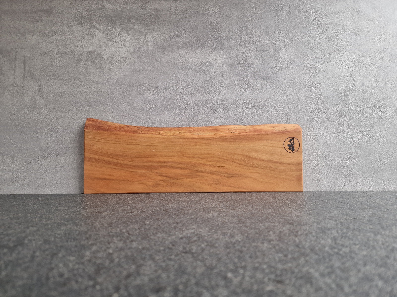Einzelstück. Magnetischer Messerhalter aus Kirschbaum mit einer Baumkante an einer Betonwand.