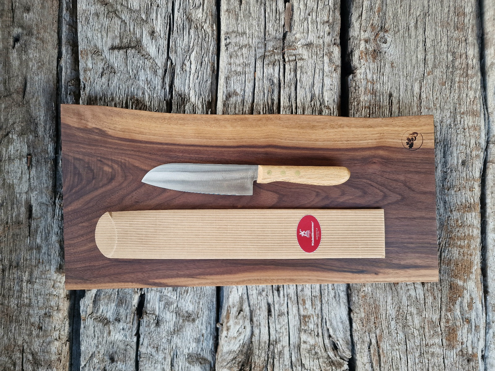 Geschenkset Vollholz Schneidebrett aus massivem Nussbaum mit Santoku Kochmesser mit Eiche Griff, fotografiert auf historischen Eichenbalken.