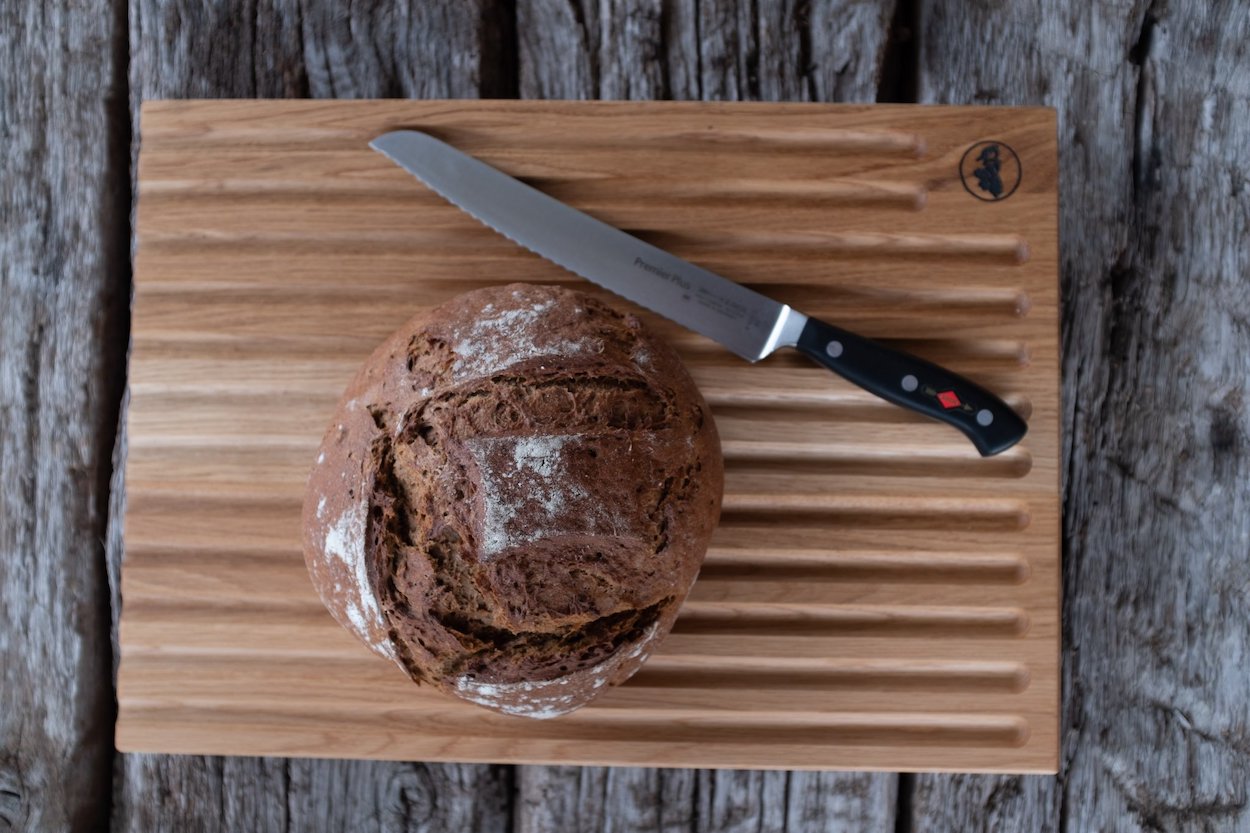 Rechteckiges großes Schneidebrett für Brot aus Eiche. Mit einem Brotmesser von DICK und einem selbstgebackenem Brot.