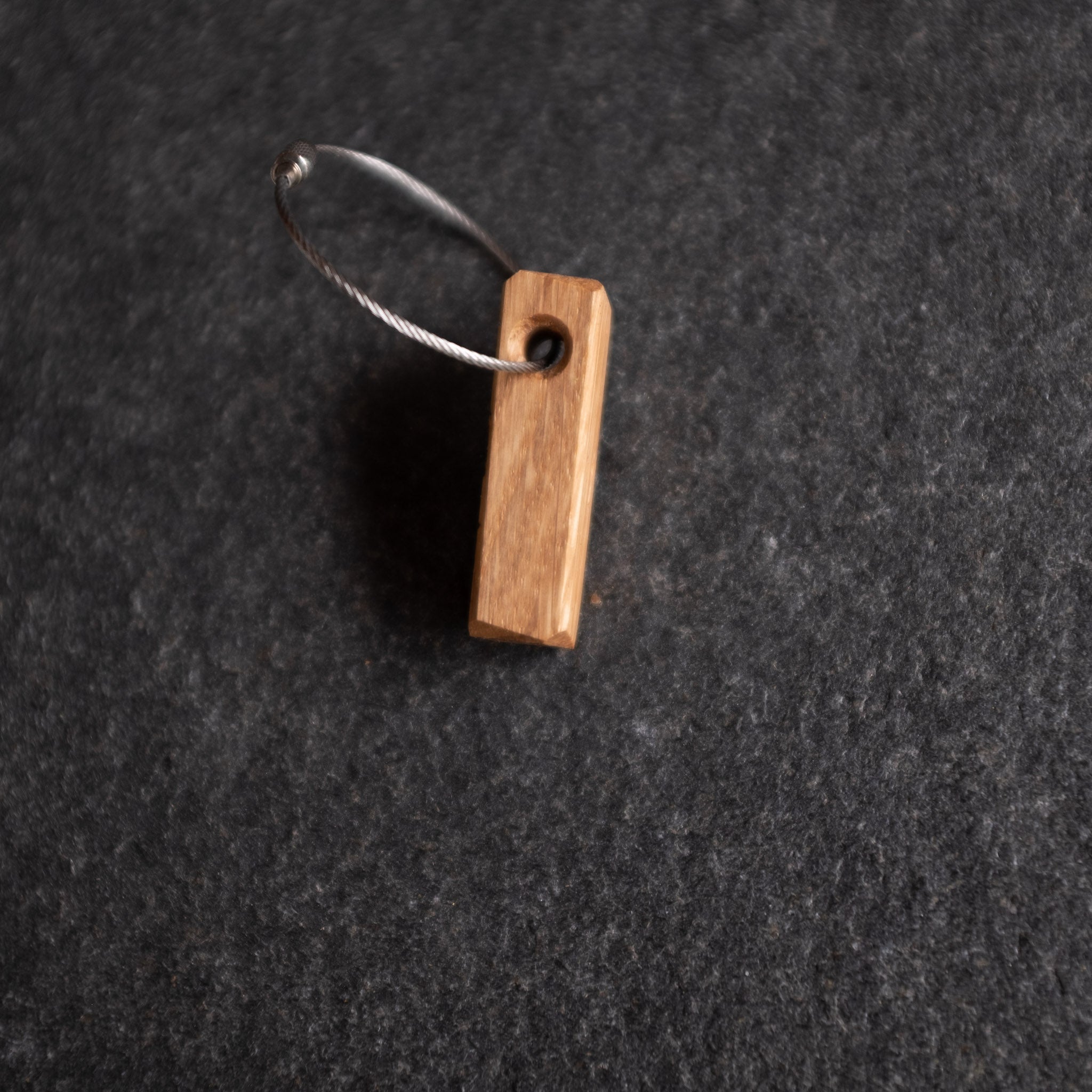 Holz Schlüsselanhänger aus Eiche auf einer Steinplatte.