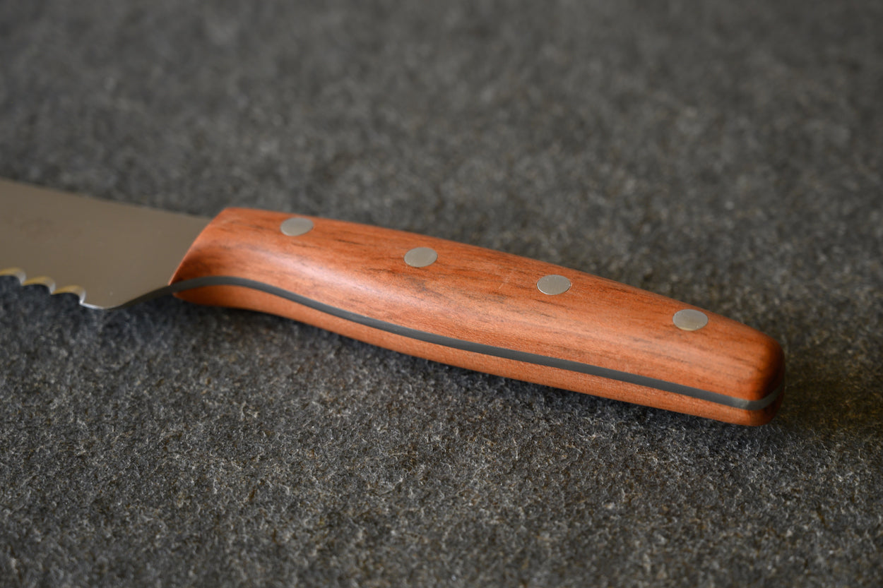 Detailansicht Holz Griff aus Pflaume von einem Brotmesser von Windmühlenmesser. 