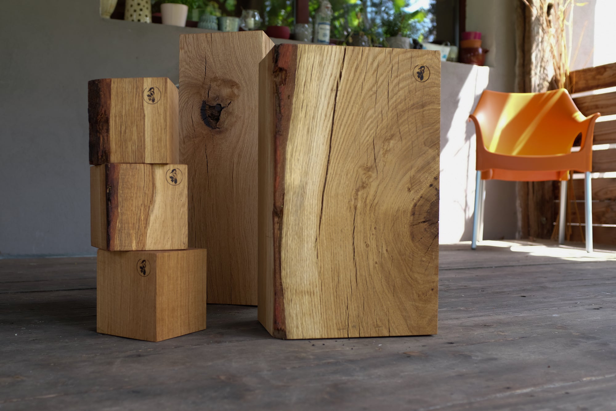 Holzklötze aus Eiche in drei verschiedenen Größen. Teilweise mit Baumkante. Fotografiert auf einem Holz Terassenboden.