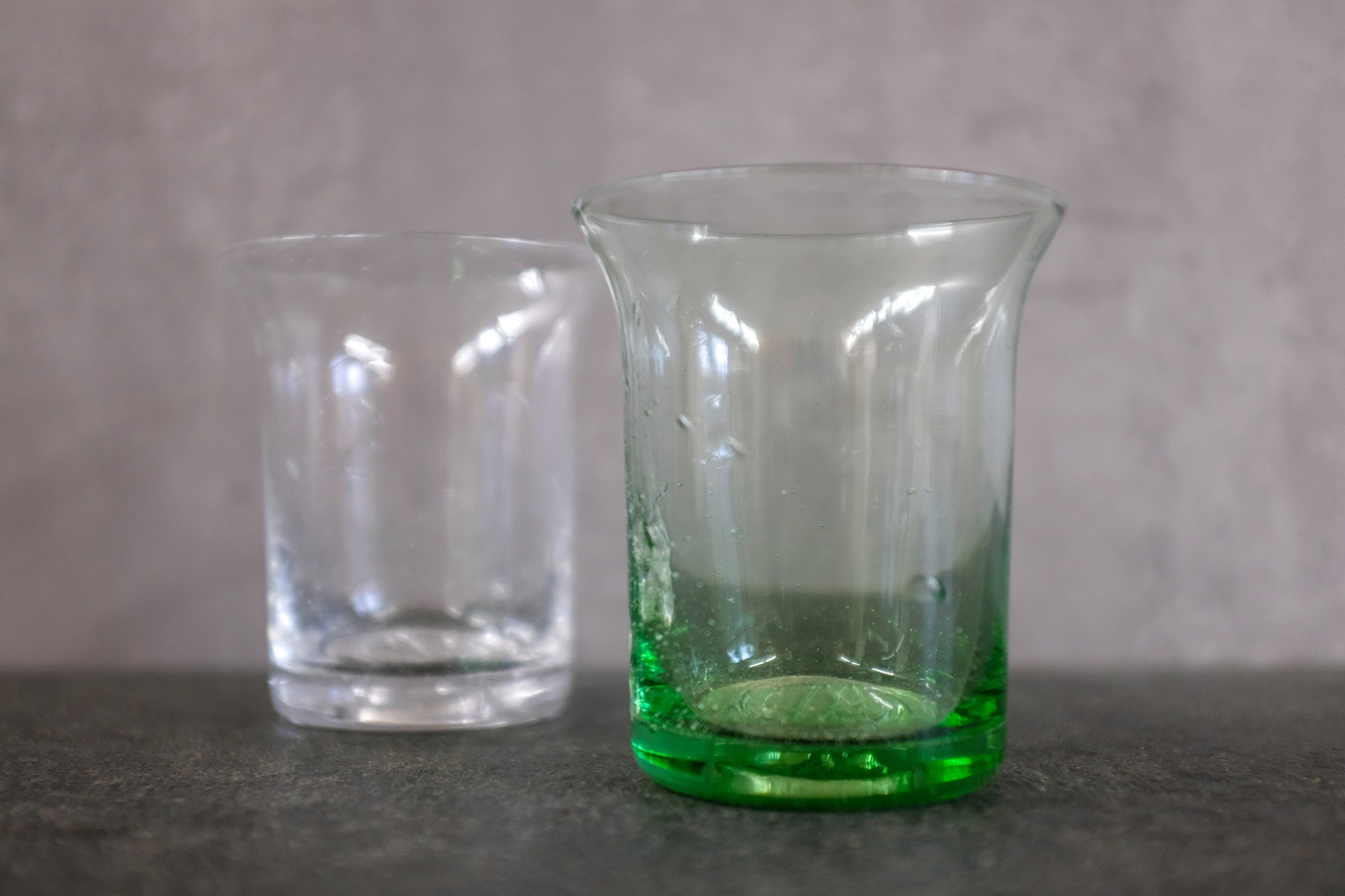 Das grüne Waldglas Goetheglas 150 ml neben einem Goetheglas in klar.