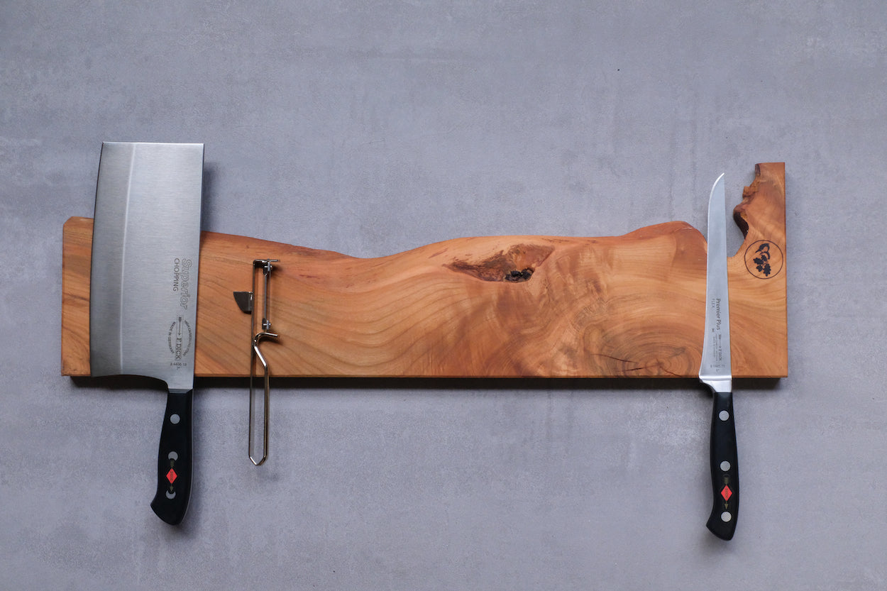 Magnet Messerleiste aus Kirschbaum, 55cm lang, mit zwei Messer und einem Sparschäler. An einer Wand montiert